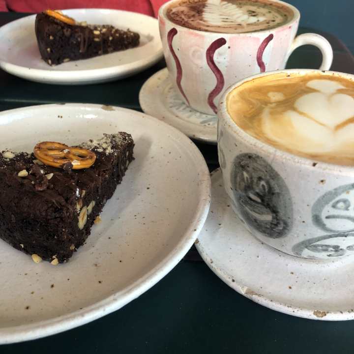 two pieces of chocolate cake and two lattes in nice cups