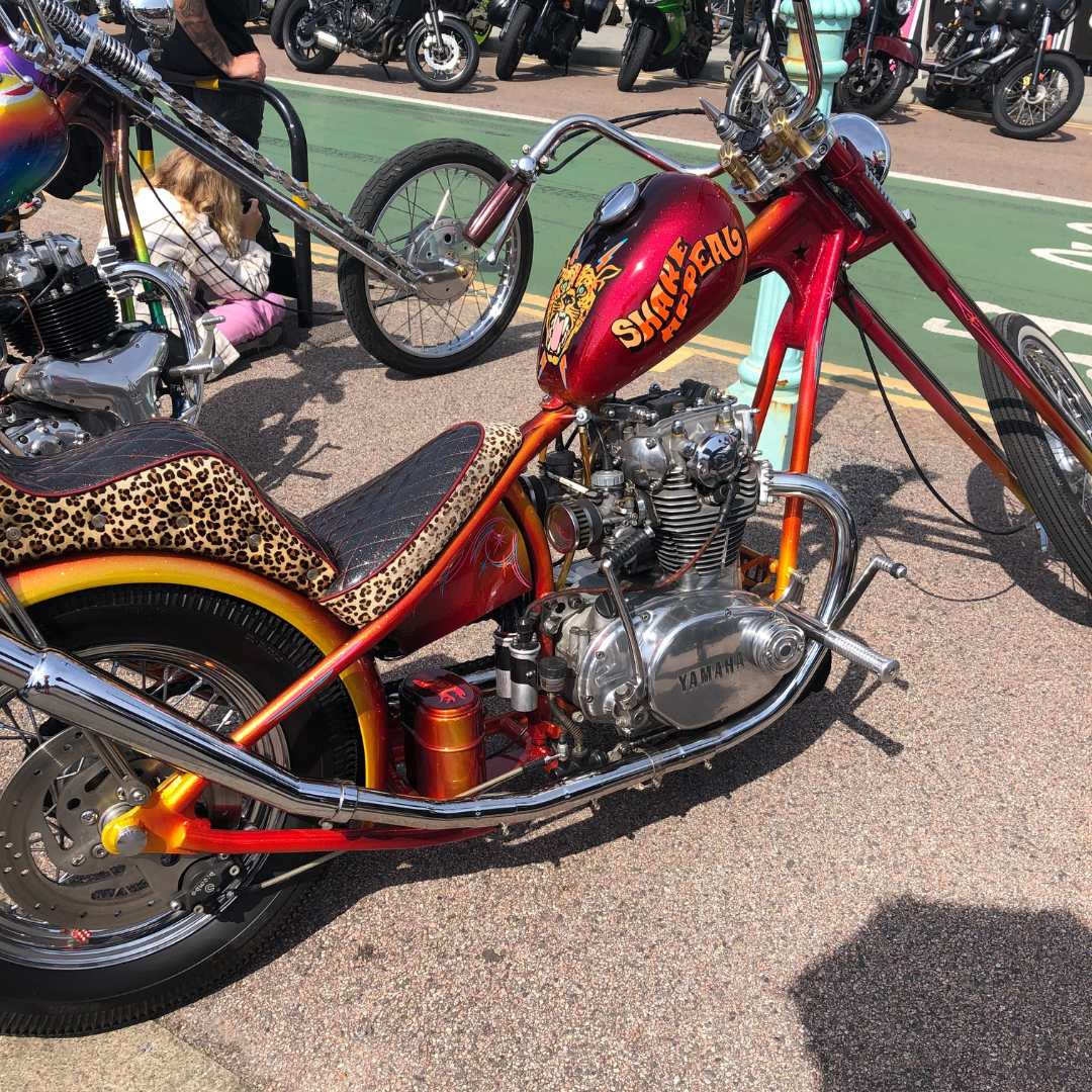 A cool Harley Davidson style motorcycle. It is orange and red